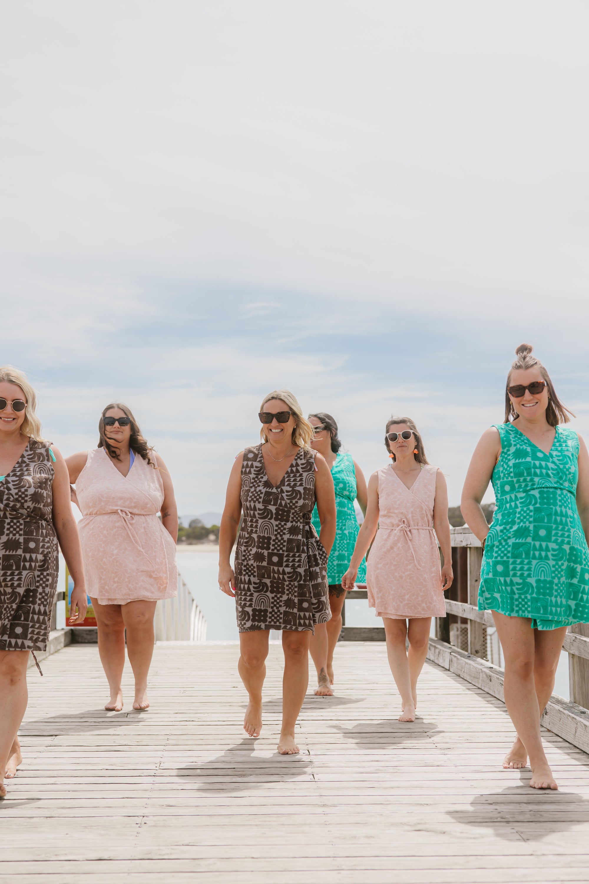 Group of women wearing Sheila May Swim Terry Wrap beach dresses.