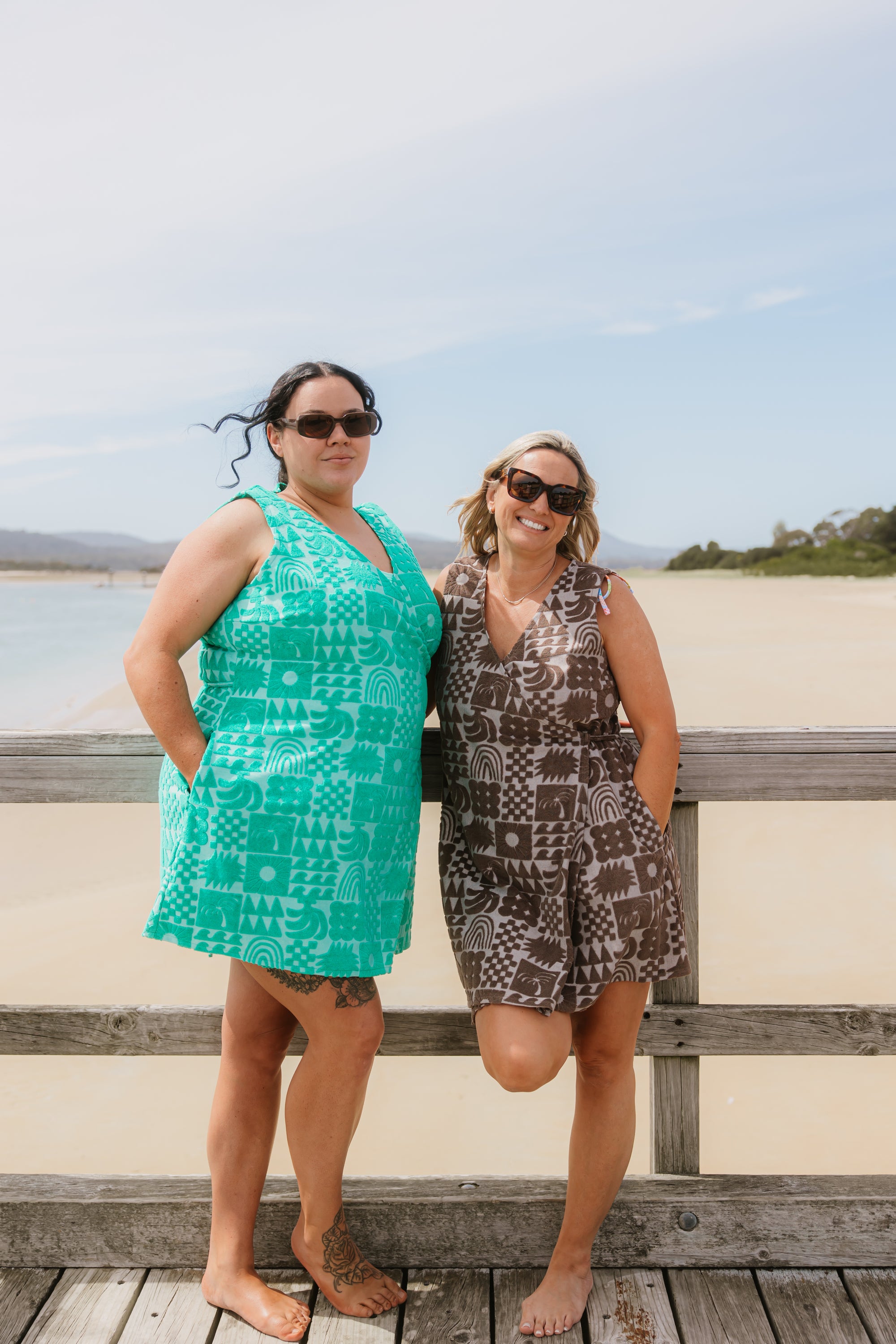 Two women wearing Sprout green and Cocoa brown terry wrap dress at the beach