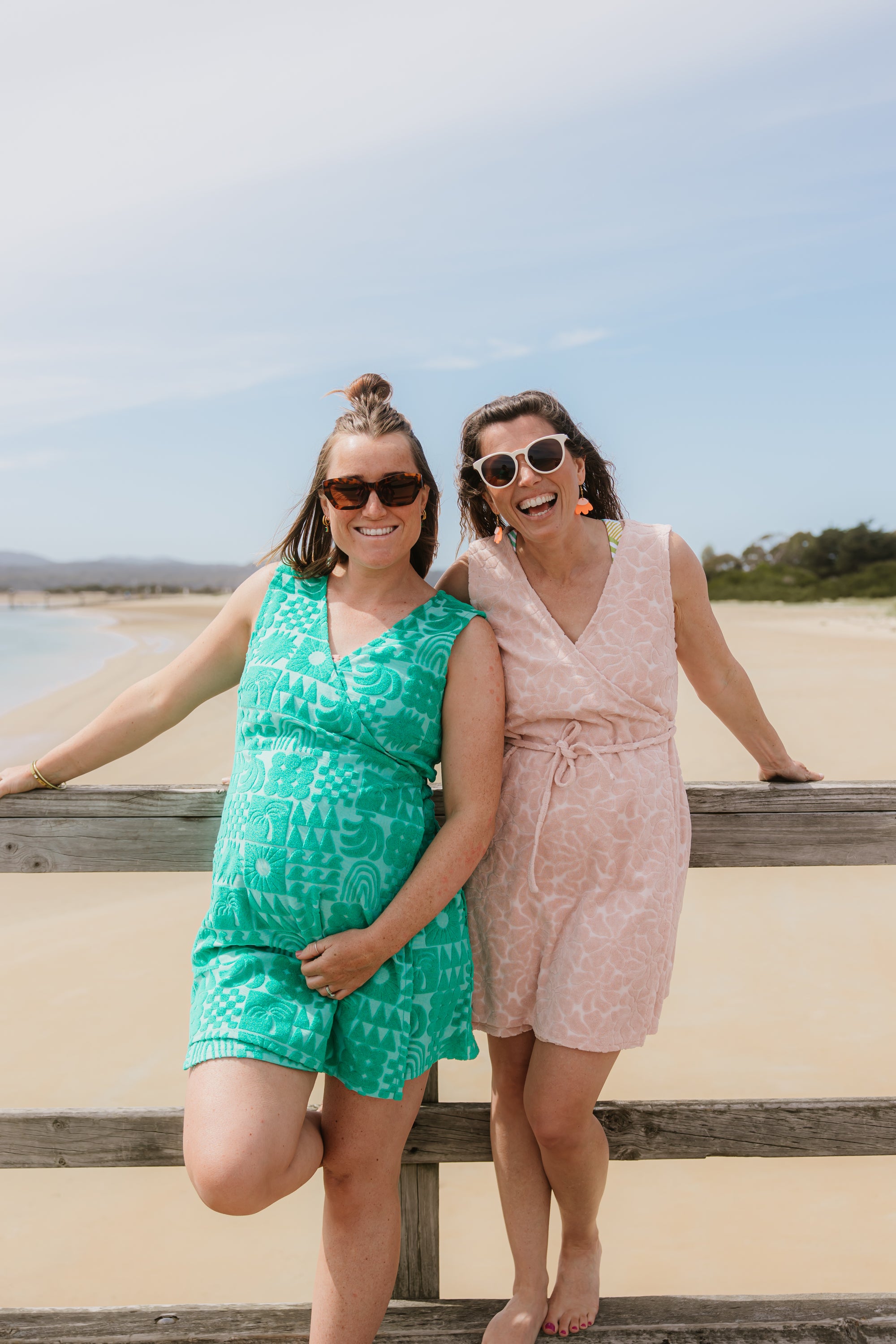 Two women wearing Sprout green and Blush light pink terry wrap dress at the beach