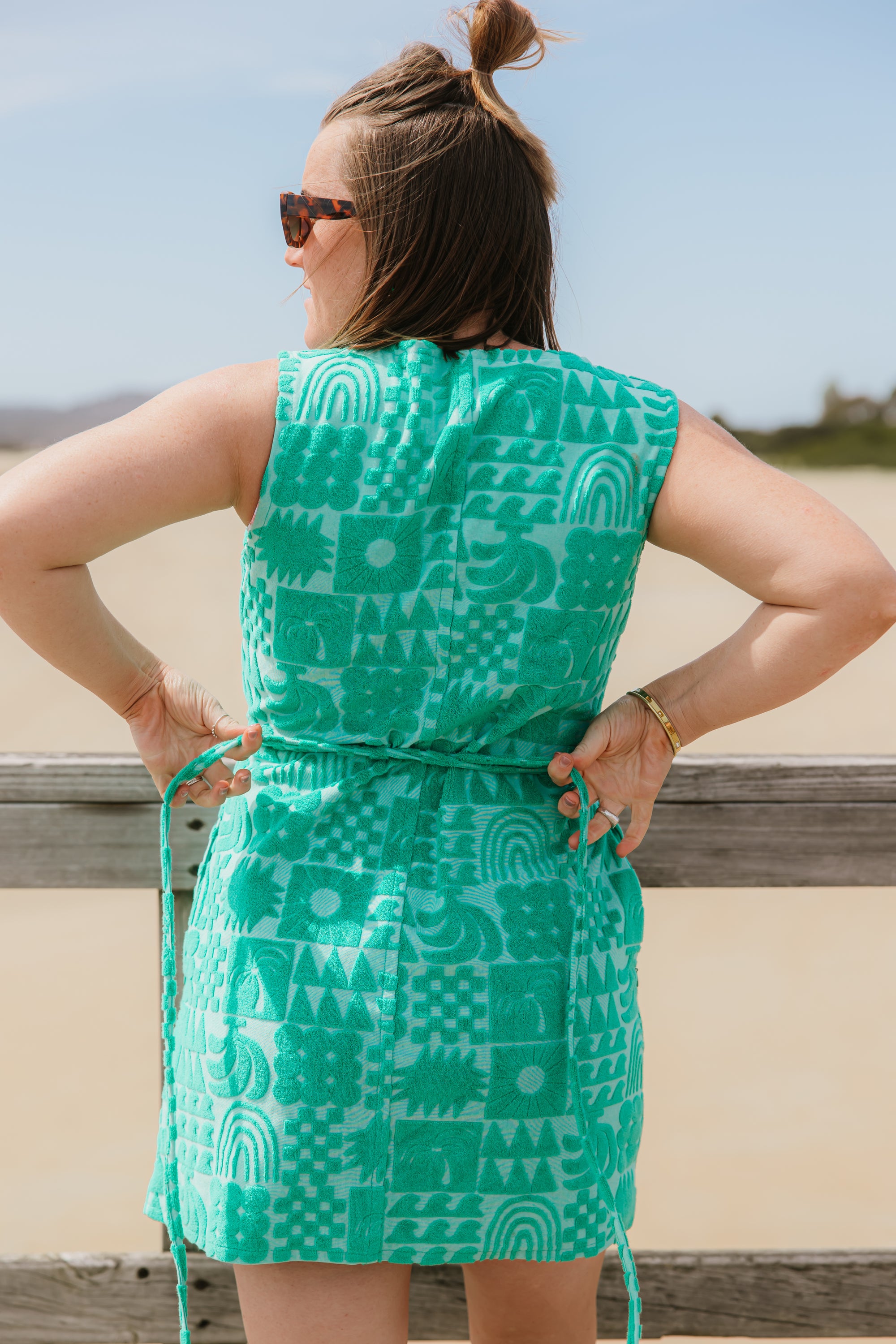 Back view of woman wearing sprout green terry wrap dress with ties