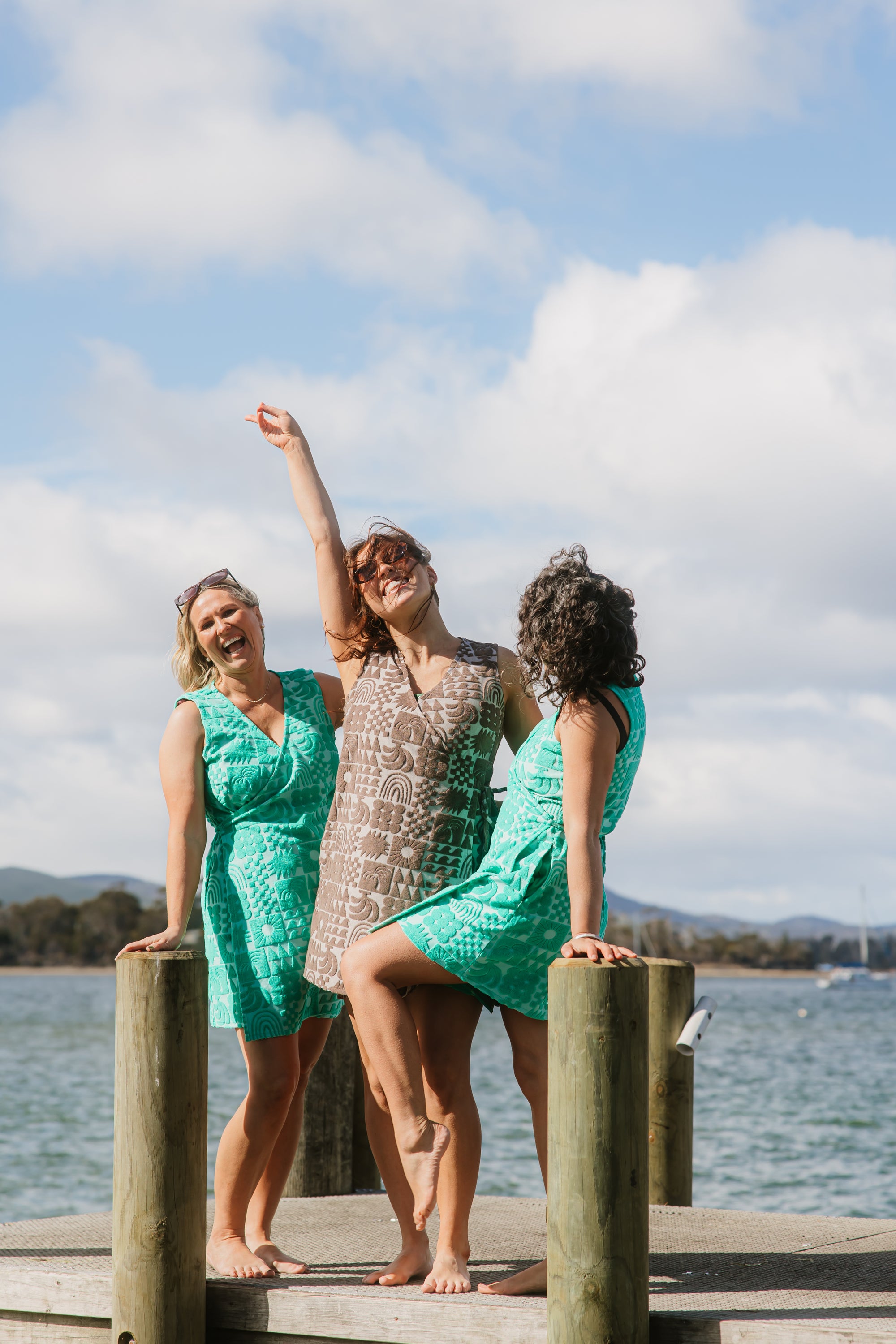 Three women wearing Sprout green and Cocoa brown terry wrap dress at the beach