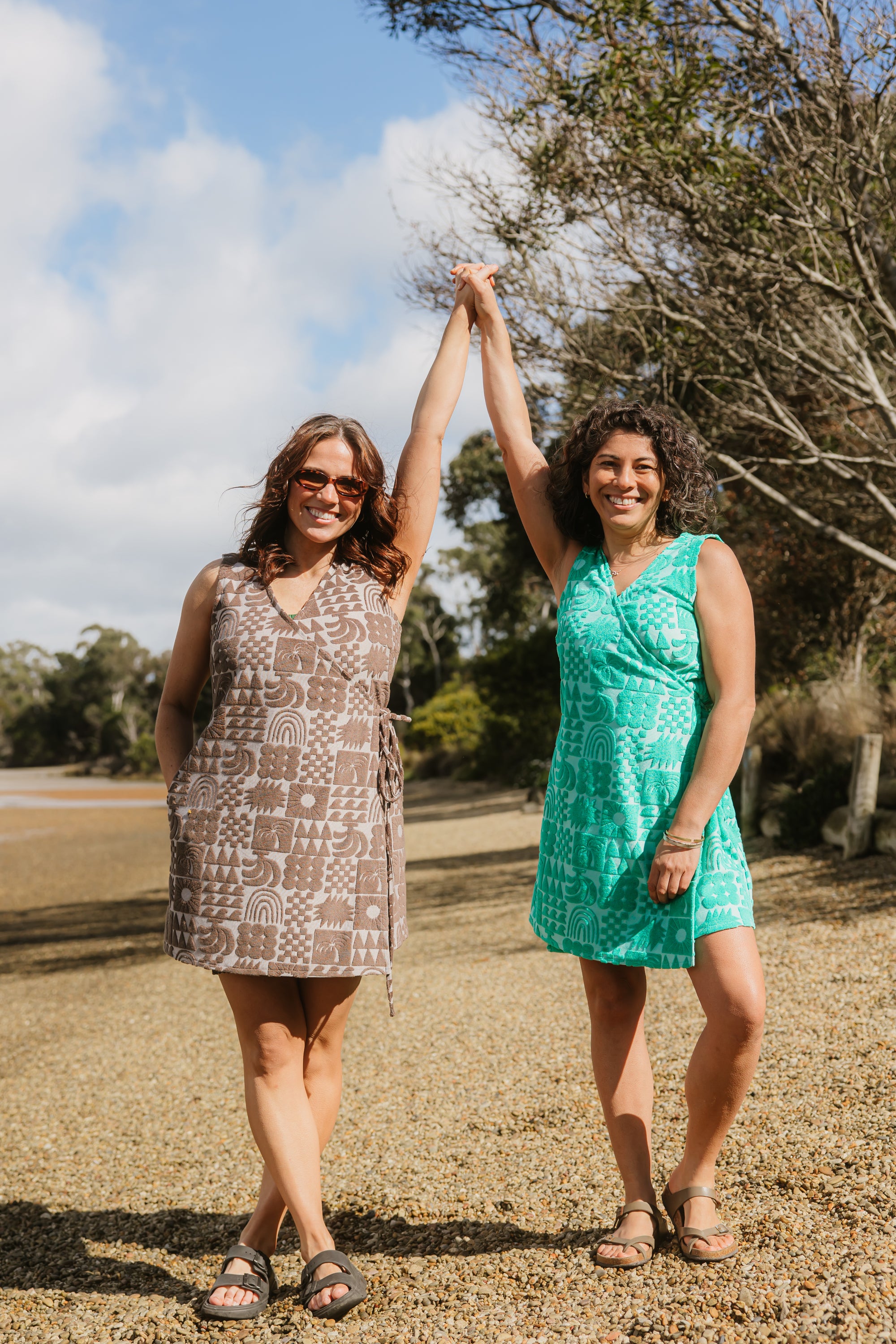 Two women wearing Sprout green and Cocoa brown terry wrap dress at the beach